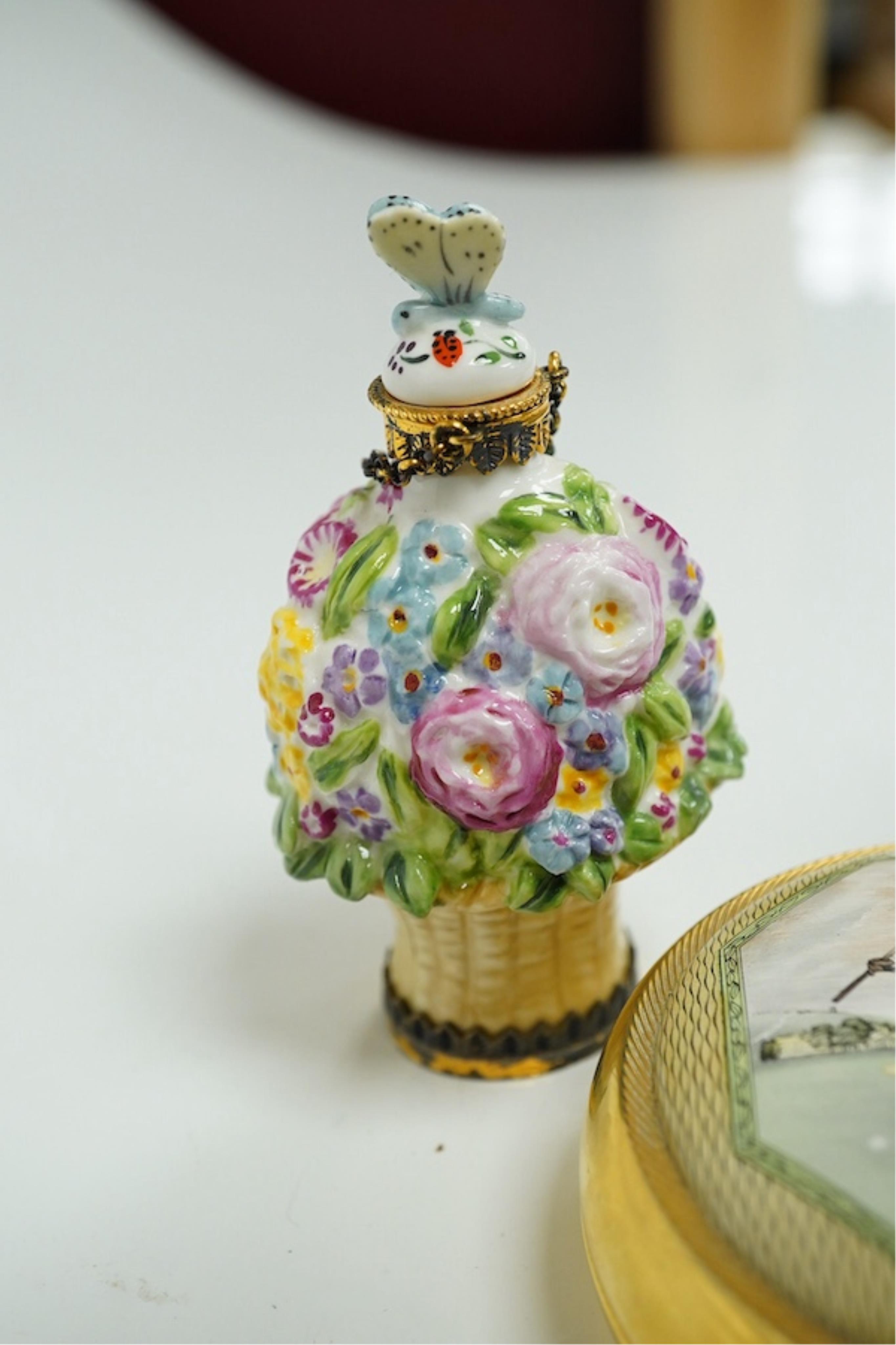 A miniature porcelain egg shaped scent bottle, on chain, two Halcyon Days scent bottles and a circular enamelled paperweight, (4). Condition - fair